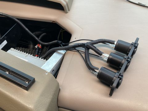 2015 Ford F-550 - A close-up view shows a set of three black electrical outlets mounted on a panel, with protective corrugated tubing covering the wires lead…