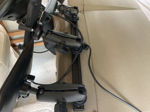 2015 Ford F-550 - A close-up view of two black RAM Mounts attached to a black rail system, holding a Garmin GPS device and other electronics. The mounts are…