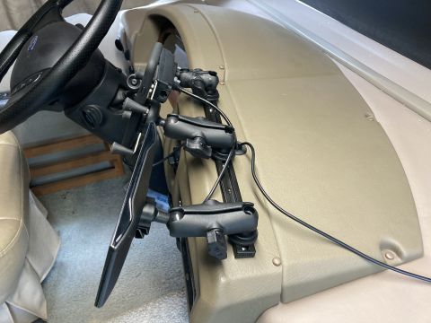 2015 Ford F-550 - A close-up view of a custom mount holding a tablet device and GPS unit on the dashboard of a vehicle, next to the steering wheel.