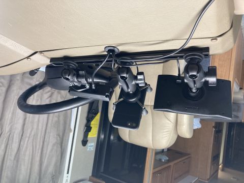 2015 Ford F-550 - A black RAM mount system is attached to the underside of a vehicle's dashboard, holding a Garmin GPS and a smartphone. The mount is secured…