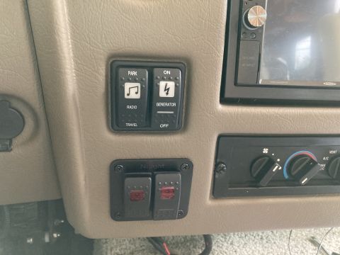 2015 Ford F-550 - A close-up interior shot shows a dashboard with several switches and a car stereo. Visible labels include 'PARK', 'RADIO', 'TRAVEL', 'ON',…