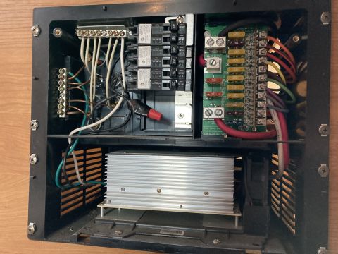 2015 Ford F-550 - A close-up view of an RV's electrical panel, showing circuit breakers, fuses, wiring, and a converter unit.
