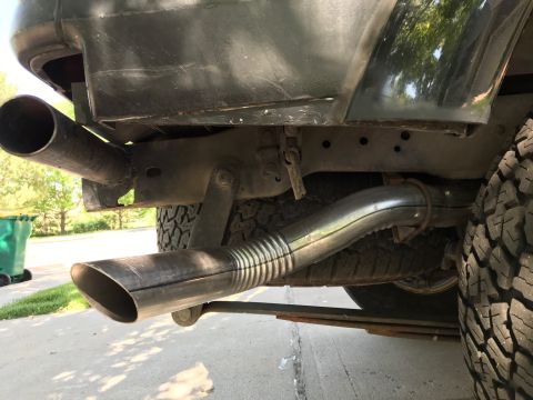 2000 Ford Explorer - Custom exhaust pipes are visible on the underside of a vehicle, near the rear tire.