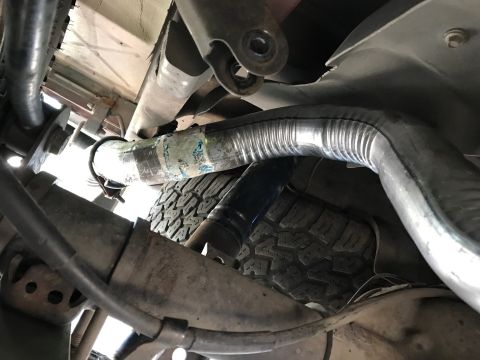 2000 Ford Explorer - A close-up view of the undercarriage reveals a damaged exhaust system and a tire.
