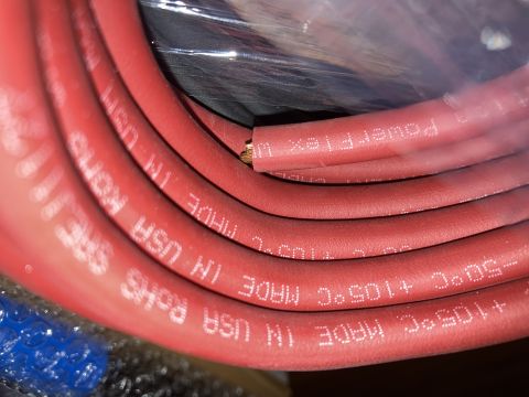 2015 Ford F-550 - A close-up, coiled red electrical cable with white text indicating it is "PowerFlex 1" and rated for "-50°C +105°C MADE IN USA".