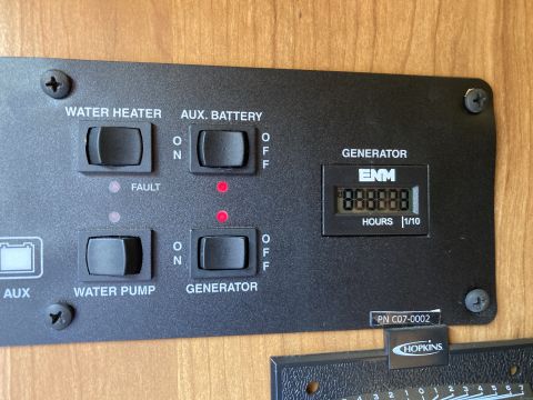 2015 Ford F-550 - A close-up view of a vehicle's control panel shows switches for water heater, auxiliary battery, water pump, and generator, along with a di…