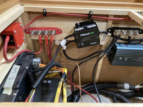 2015 Ford F-550 - A close-up view of a complex electrical system with multiple red and black wires, a black Xantrex PROWATT SW inverter, and a red battery te…
