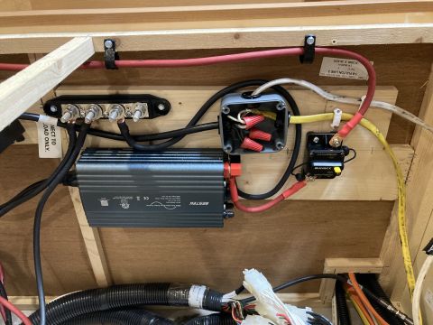 2015 Ford F-550 - Bestek inverter wired to a bus bar, junction box, and battery isolator with heavy red and yellow cabling mounted to a wood backing.