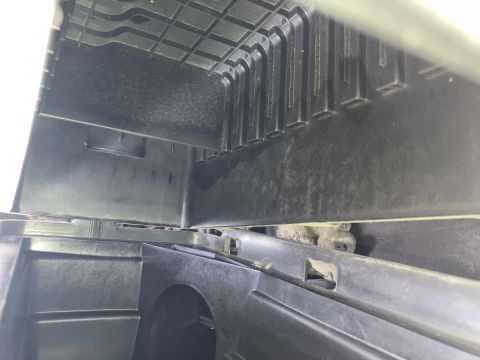 2015 Ford F-550 - A close-up, low-angle view of the underside of black plastic components, possibly from a vehicle's interior or undercarriage. The textured…