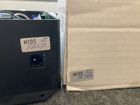 2015 Ford F-550 - Close-up of an electronic device and its packaging, with handwritten labels indicating identification numbers.