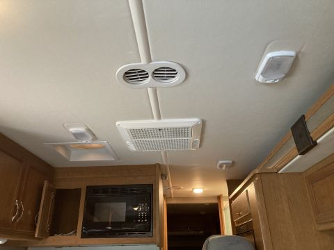 2015 Ford F-550 - Interior view of an RV ceiling, an air conditioning unit and lighting fixtures.