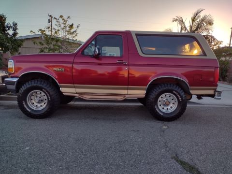 1994 Ford Bronco - This 1994 Ford Bronco features a two-tone paint scheme with a red body and tan accents.