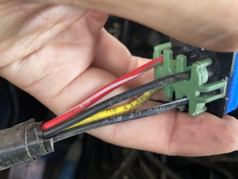 2015 Ford F-550 - A hand manipulates electrical wires connected to a green and blue connector.