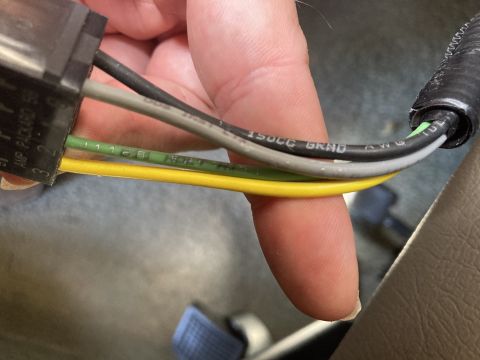 2015 Ford F-550 - A close-up shot shows a hand holding a wiring harness with several colored wires and printed text.