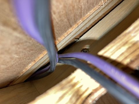 2015 Ford F-550 - Close-up view of electrical wiring passing through a wooden structural opening.