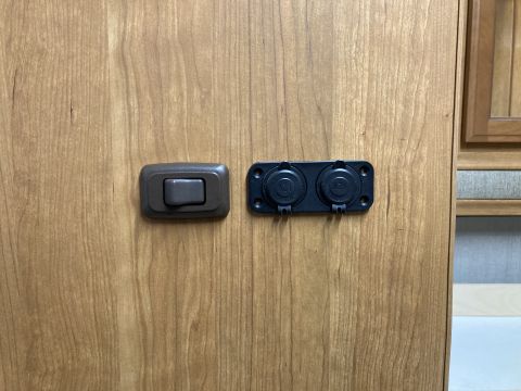 2015 Ford F-550 - Close-up of electrical outlets and a switch inside a vehicle's interior, likely an RV or camper.