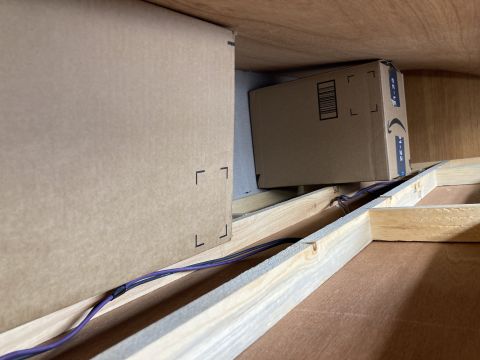 2015 Ford F-550 - Cardboard boxes and wiring are visible inside a wooden structure, possibly a storage area or custom build.