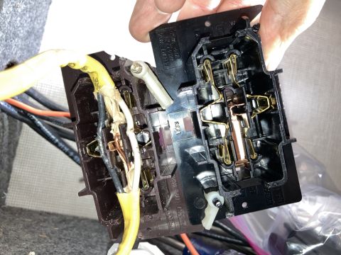 2015 Ford F-550 - A hand is shown holding an electrical fuse box with exposed wiring and metal connectors.
