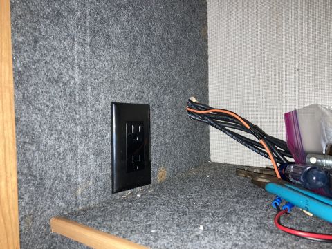 2015 Ford F-550 - Close-up of an electrical outlet and wiring inside a cabinet, with tools visible.
