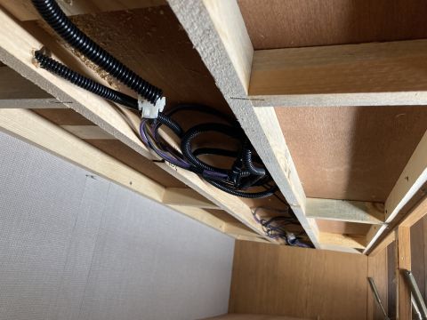2015 Ford F-550 - The underside of RV cabinetry reveals a network of wooden beams and electrical wiring, suggesting an interior view of the vehicle's constru…