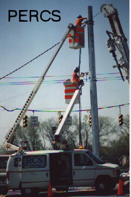 1994 Ford Bronco - Utility workers in bucket trucks perform maintenance on power lines above a parked PERCS van.