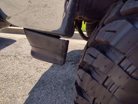 1994 Ford Bronco - Close-up of a damaged fender flare and a tire on an unidentified vehicle.