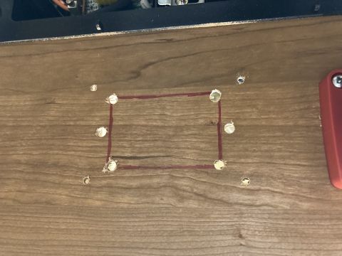 2015 Ford F-550 - A red rectangular outline is drawn on a wood-grain surface, with several holes drilled around it.