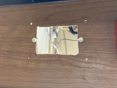 2015 Ford F-550 - A rectangular cutout in a wood panel reveals electrical wiring and components.