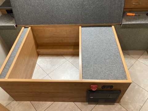 2015 Ford F-550 - Interior view of an RV storage compartment, showing wooden construction and an electrical panel.