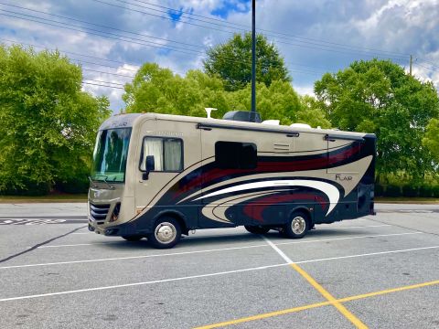 2015 Ford F-550 - A motorhome with a distinctive graphic design on its side is parked in a lot.