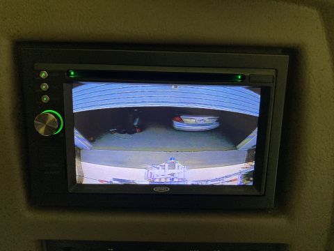 2015 Ford F-550 - Display shows a car inside a garage, viewed from a backup camera.