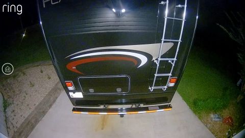 2015 Ford F-550 - Rear view of a black RV, a ladder and reflective tape on the bumper.