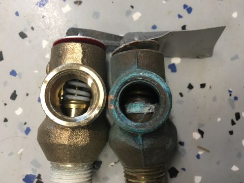 1995 Chevrolet P30 1 Ton - Step Van - Comparison of a new pressure relief valve next to a corroded one, showing wear and tear.