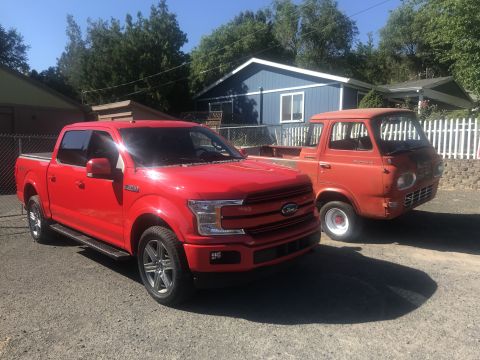 2018 Ford F-150 - A modern red Ford F-150 is parked next to a vintage orange pickup truck on a sunny day.