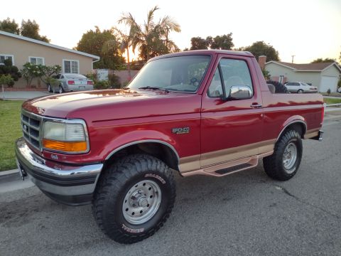1994 Ford Bronco - This 1994 Ford Bronco features a two-tone paint scheme with tan trim and aggressive off-road tires.