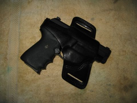 2002 Ford Taurus - A pistol is shown secured in a leather holster against a textured background.