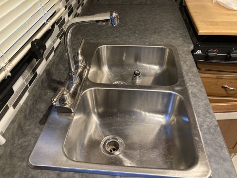 2015 Ford F-550 - Kitchen sink with a chrome faucet and a tiled backsplash.