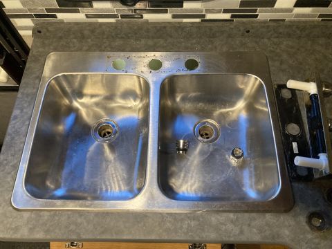 2015 Ford F-550 - A stainless steel double basin sink is shown, with holes for a faucet and drain assemblies.