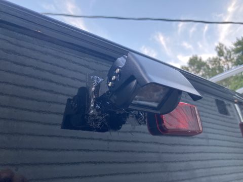 2015 Ford F-550 - An aftermarket backup camera is attached with tape to the rear of a vehicle, obscuring a red taillight.