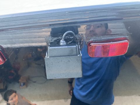 2015 Ford F-550 - A camera is attached to the rear bumper of a vehicle, next to a red taillight.