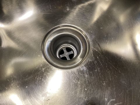 2015 Ford F-550 - The drain in this stainless steel sink has a cross-shaped strainer visible inside.