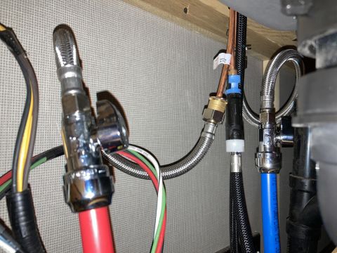 2015 Ford F-550 - Close-up view of plumbing and wiring connections, showing various pipes, hoses, and electrical cables.