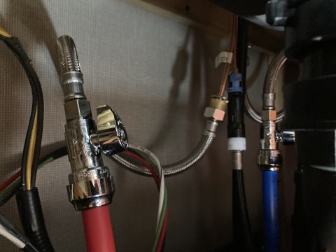 2015 Ford F-550 - Close-up view of plumbing connections under a sink, including a chrome valve and various water lines.