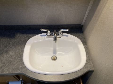 2015 Ford F-550 - A close-up view of a white sink and faucet in a bathroom setting.