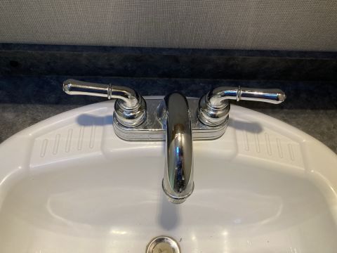 2015 Ford F-550 - A chrome faucet with two handles is mounted on a white sink.