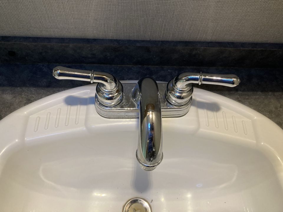 Chrome faucet with two handles on a white sink