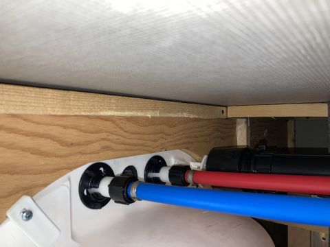 2015 Ford F-550 - Plumbing pipes and fittings are visible under a wooden structure, with a Supermotors.net logo in the corner.