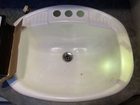 2015 Ford F-550 - A white sink with a drain and faucet holes is shown.