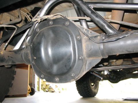 1995 Ford Bronco - The underside of a vehicle shows the rear differential, suspension, and a custom roll cage structure.