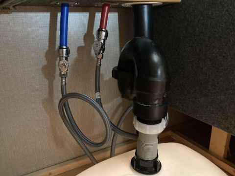 2015 Ford F-550 - Plumbing components are visible beneath a sink, including water supply lines and a drain pipe.